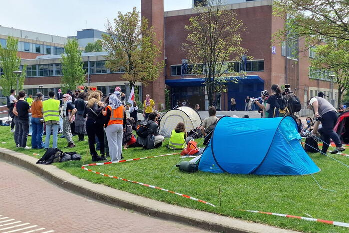 Studenten in tenten op grasveld bij UvA